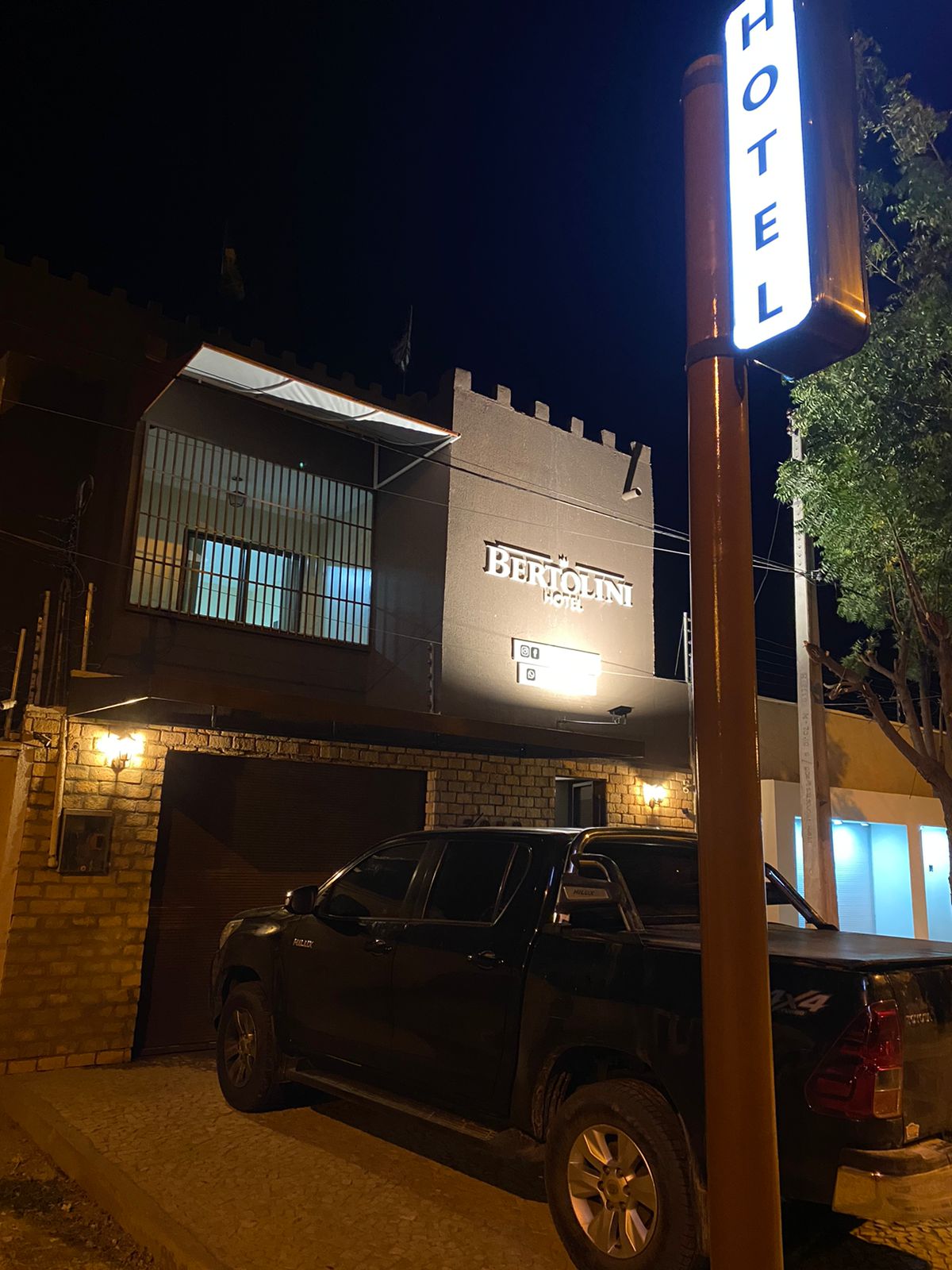 Fachada iluminada do Bertolini Hotel à noite